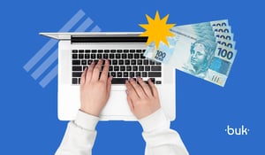 Mãos digitando em notebook com notas de 100 reais ao lado, ilustrando o cálculo da restituição do imposto de renda 2025 online.