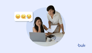 Profissional de RH sobrecarregada sendo cobrada pela gestora enquanto analisa documentos no notebook, representando o conflito entre RH operacional e RH estratégico no ambiente de trabalho
