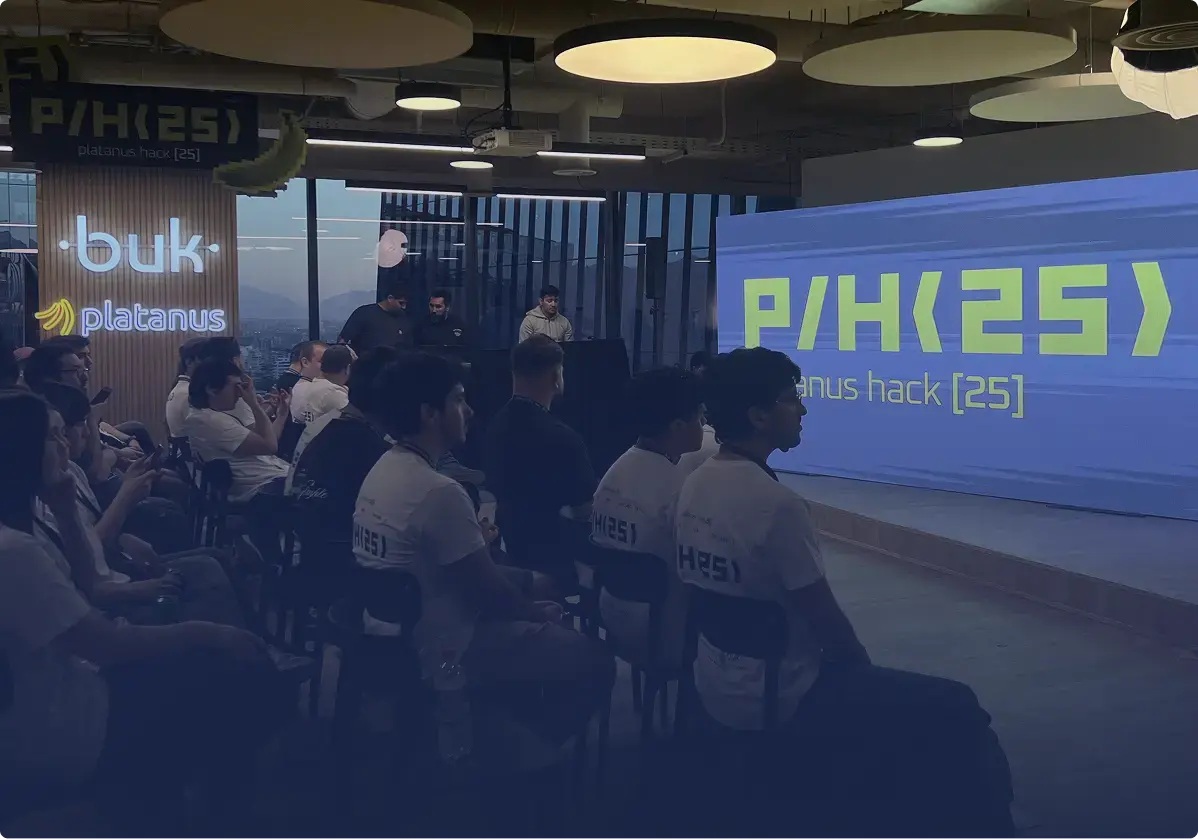 Palco do hackathon Platanus Hack 25 com participantes em primeiro plano